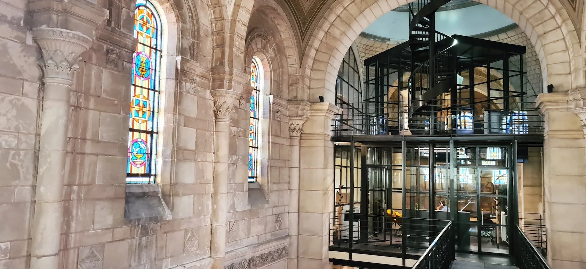 Un vitrail ancien en regard d'une cage vitrée métallique